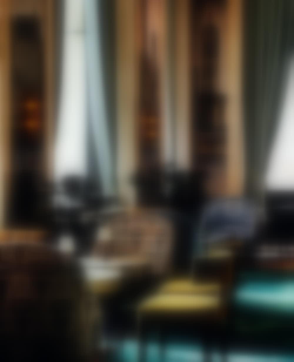 The lounge of The Wall Street Hotel, seen low across the chairs, lit by its amber wall sconces.