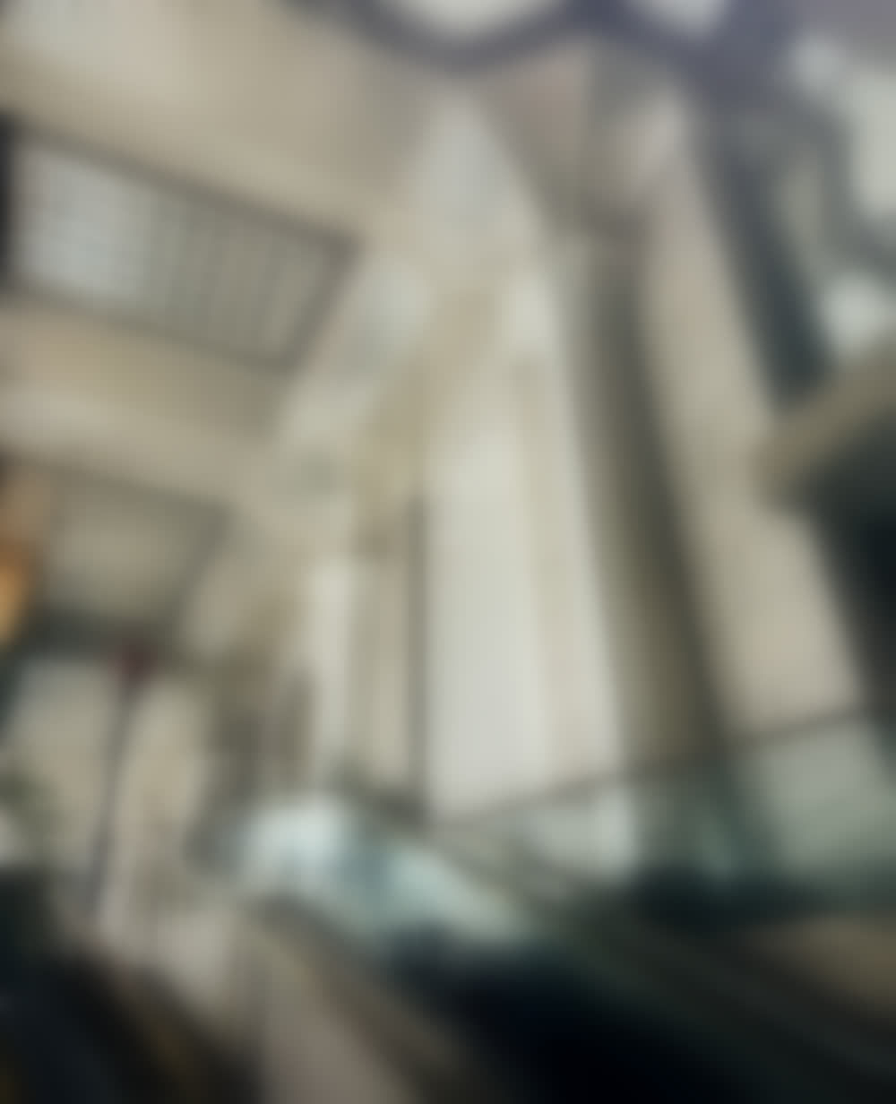 The vaulted lattice atrium of 60 Wall Street, its flared piers rising to a coffered ceiling.