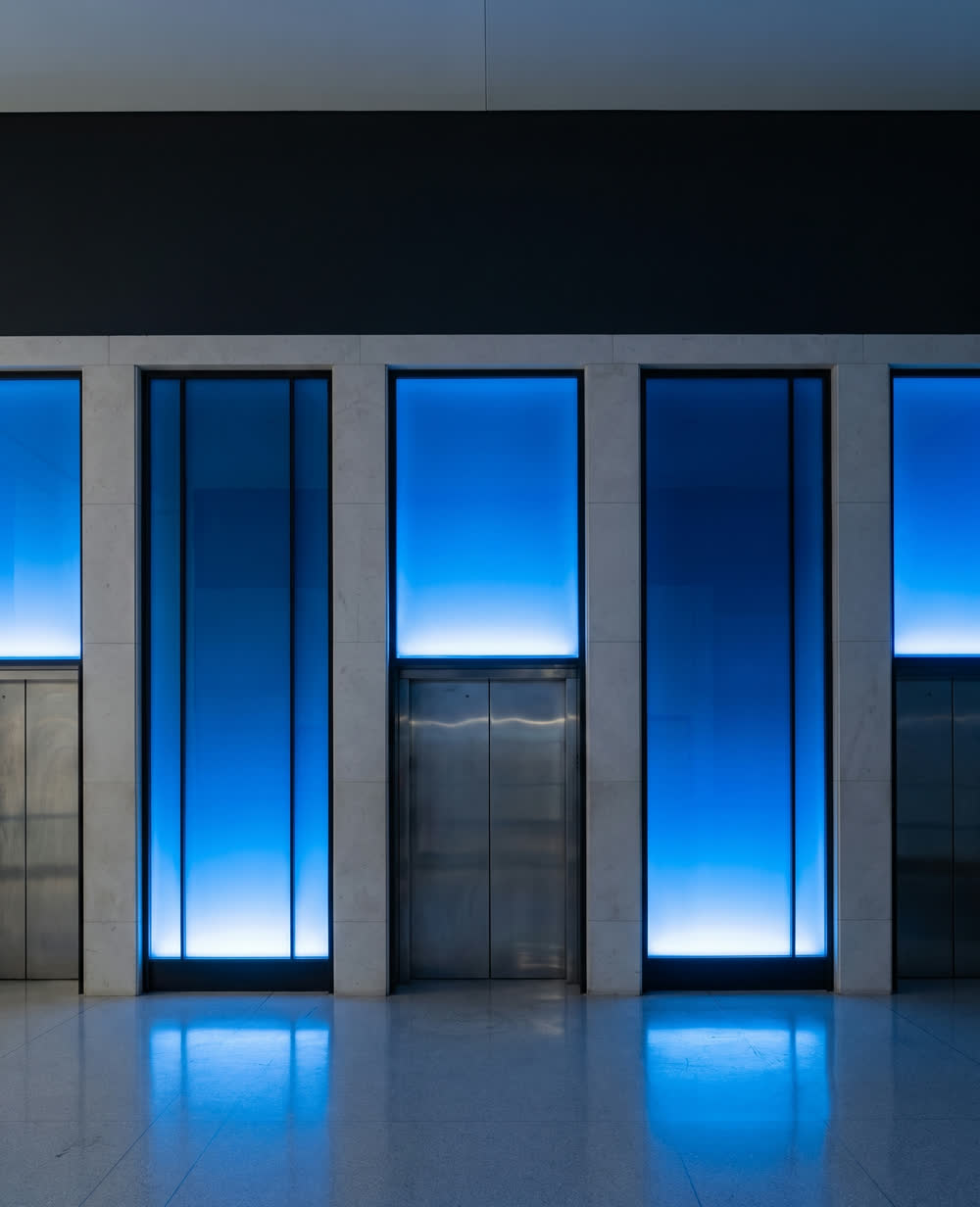 A lift lobby lit by tall recessed blue panels.