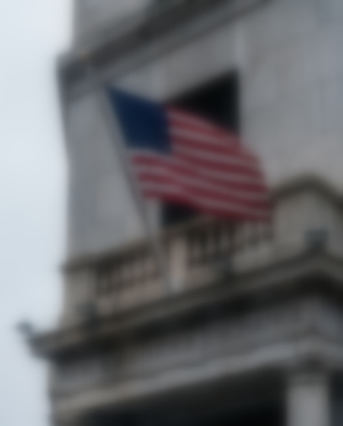 The New York Stock Exchange, its carved frieze and a United States flag.