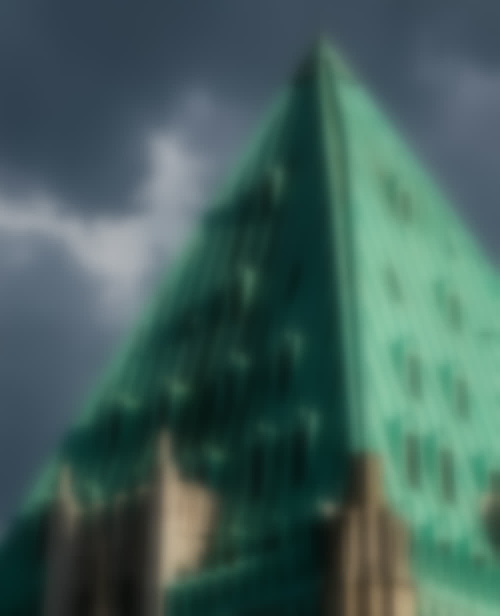 The verdigris copper crown of 40 Wall Street seen from street level.